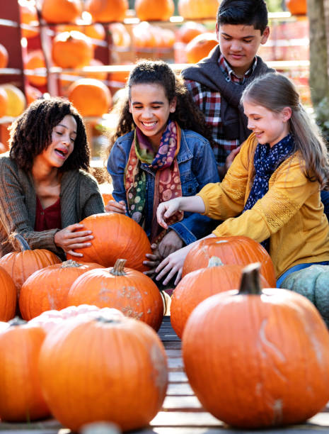 istock Four pre-teen children having fun at pumpkin patch 1336578864