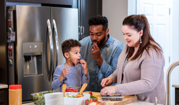 istock Multi-ethnic family with boy in kitchen making lunch 1336579034
