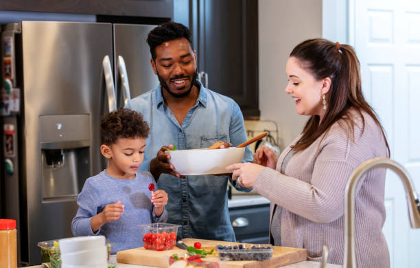 istock Multi-ethnic family with boy, in kitchen making lunch 1336579056