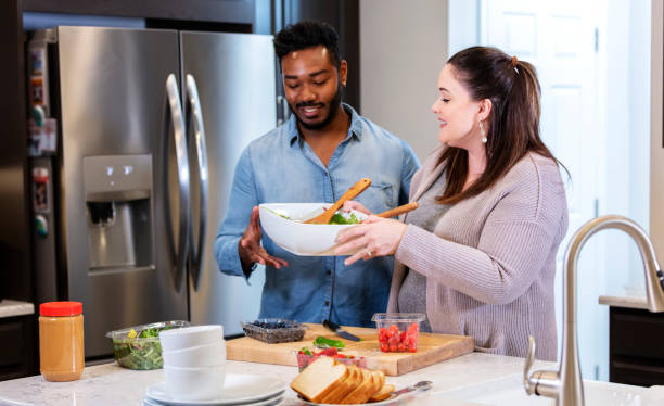 istock Interracial couple in kitchen preparing healthy lunch 1336579065