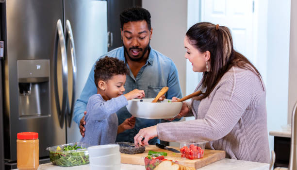 istock Multi-ethnic family in kitchen making healthy lunch 1336579069