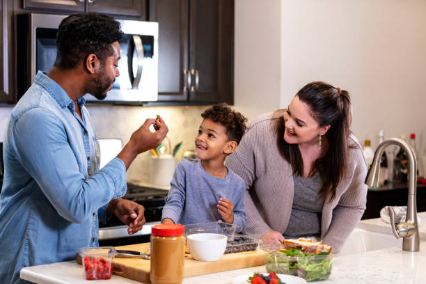 istock Family in kitchen making lunch, boy smiling at father 1336579616
