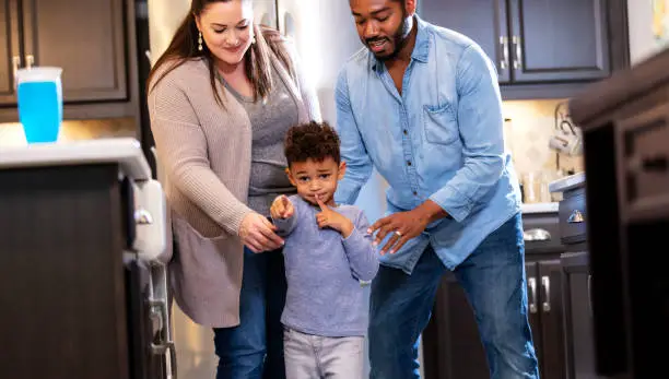 Photo of Multi-ethnic family, doting on boy who wants something