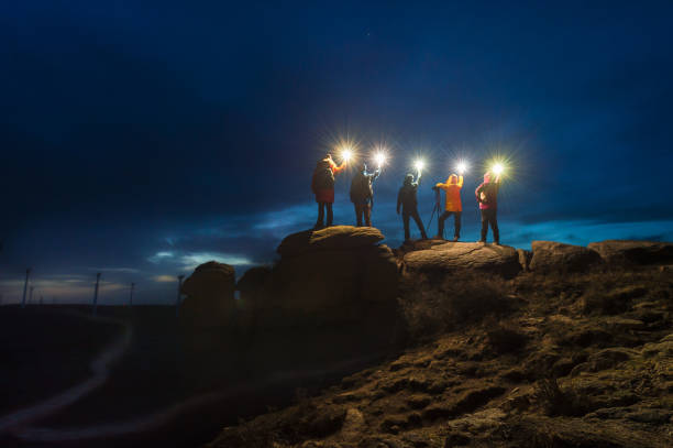 un gruppo di fotografi del cielo notturno in piedi sulla pietra con la lampada di notte - cliffside foto e immagini stock