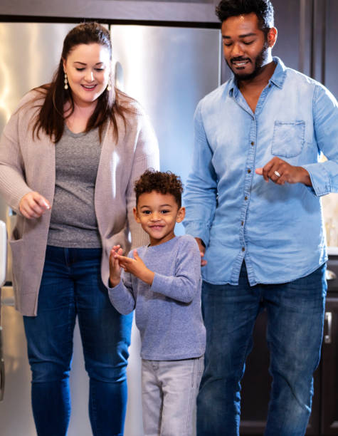istock Multi-ethnic family with boy, standing in kitchen 1336579741