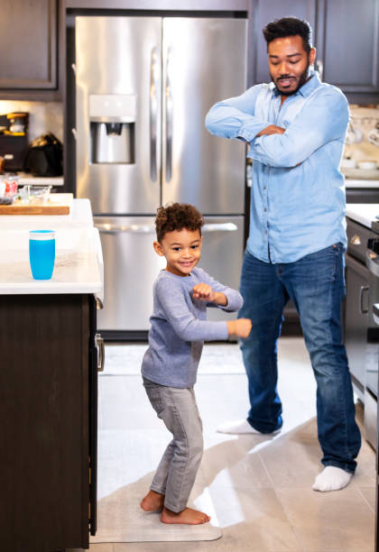istock Mixed race boy with father dancing in kitchen 1336579786