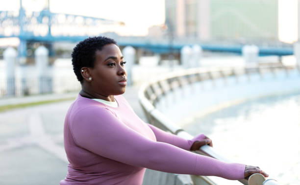 femme afro-américaine sérieuse dans le parc de la ville, pensant - overweight women serious people photos et images de collection