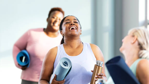 three multi-ethnic women arriving at exercise class - gym women inside of exercising imagens e fotografias de stock