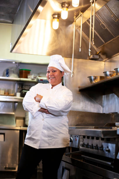 istock Female chef in commercial kitchen smiling at camera 1336580769