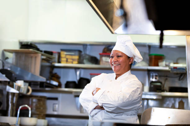 istock Female chef in commercial kitchen smiling, arms folded 1336580772