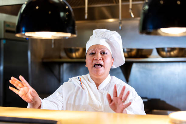 istock Female chef in commercial kitchen talking behind counter 1336581854