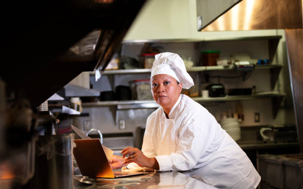 istock Female chef in commercial kitchen using laptop 1336582914