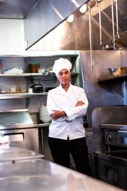istock Female chef standing in restaurant kitchen, arms crossed 1336585000