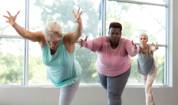 istock Three mature women taking yoga class, in warrior 3 pose 1336585511