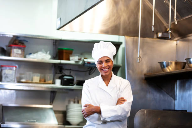 istock Female chef standing in restaurant kitchen, arms crossed 1336585513