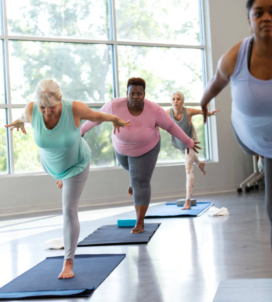 istock Four women taking yoga class, in warrior 3 pose 1336585526