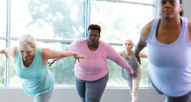 istock Four women taking yoga class, in warrior 3 pose 1336586038