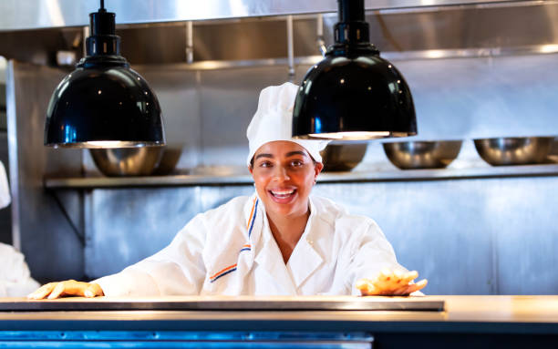 istock Woman working as chef in commercial kitchen, smiling 1336587076
