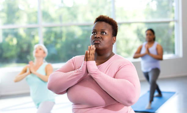 istock Three women taking yoga class, in warrior 1 pose 1336587081