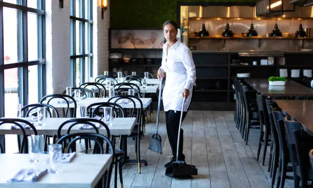 Photo of Restaurant worker sweeping the floor