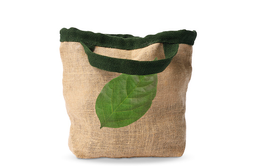 Burlap tote bag with leaves printed, isolated on white with clipping path. \nConcept of environmental and recycling.