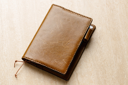 Brown leather diary on a table top.