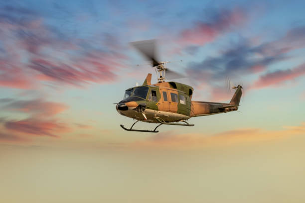 istock Silhouette Helicopter flying on with sky with soft sunsky background. 1336602208