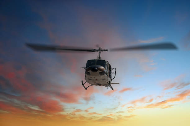 Silhouette Helicopter flying on with sky with soft sunsky background.