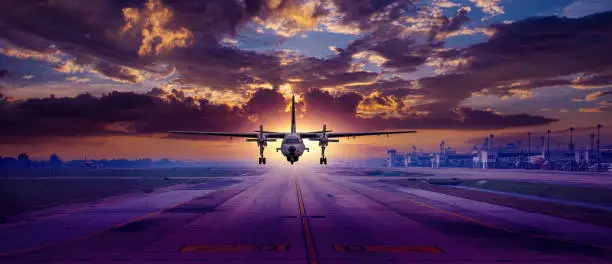 Airplane passenger or cargoplane is take off flying away go to high altitude during sunset time sky background.