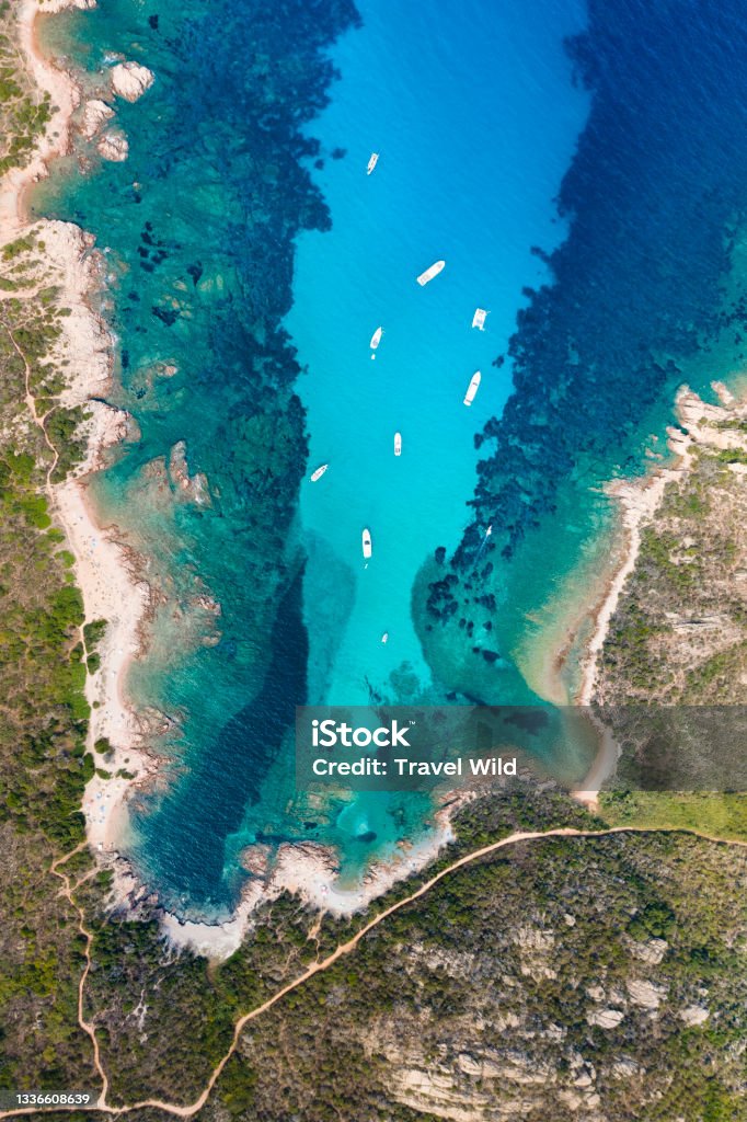 View from above, stunning aerial view of a green and rocky coastline bathed by a turquoise, crystal clear water. Costa Smeralda, Sardinia, Italy. Italy Stock Photo