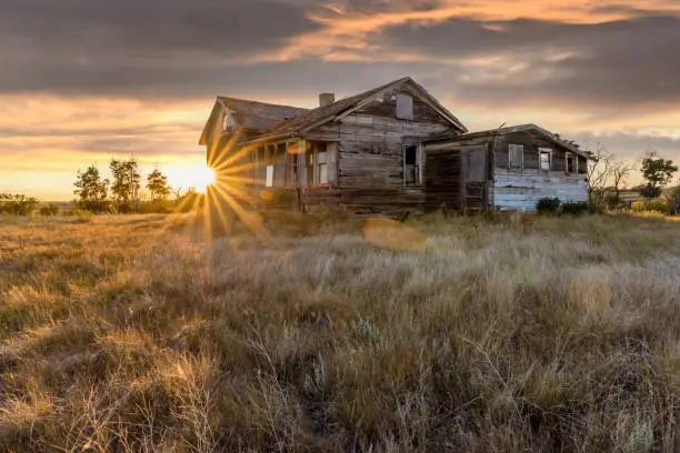 Photo of Abandoned home in a farmyard at sunset