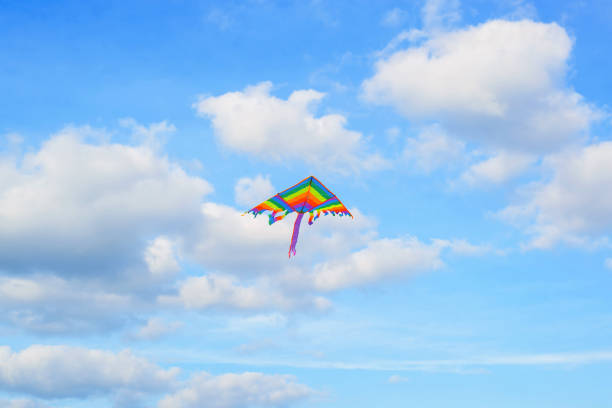 istock Rainbow kite flies high in blue cloudy sky. Freedom symbol, rainbow, lgbt concept 1336611277