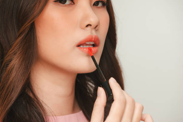 istock Beautiful Young Woman Apply Moisturizing Lip Gloss 1336611872