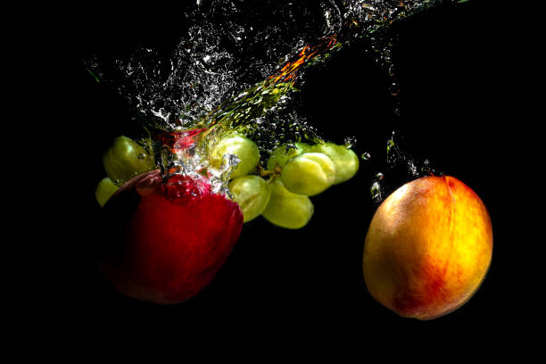 istock Fruits and grapes falling into the water with splashes and bubbles. 1336613109