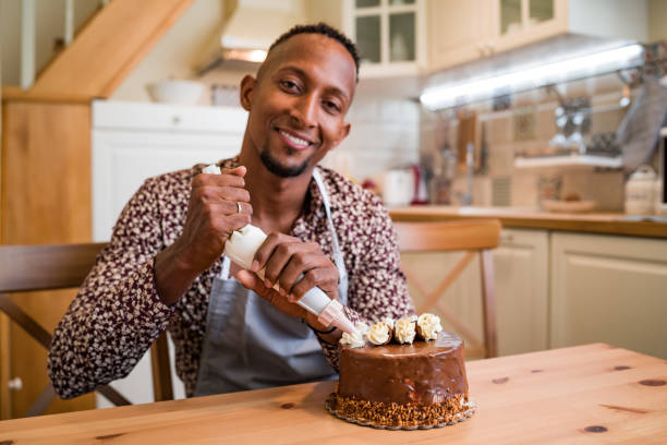 istock Brazilian man decorating a cake at home 1336616257