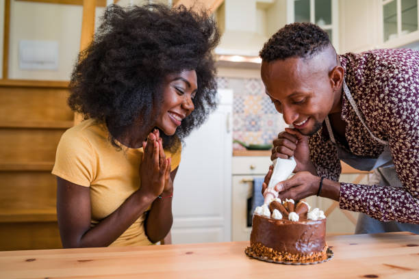 istock Couple in love decorating a cake at home 1336616262