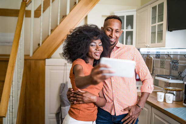 istock Young couple in the kitchen room drinking coffee and taking selfie 1336616269
