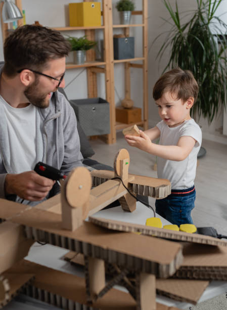 istock Father making cardboard airplane for his toddler son 1336617709