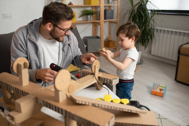 istock Father making cardboard airplane for his toddler son 1336617876