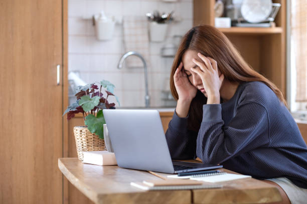 uma mulher fica doente e estressada enquanto trabalha ou estuda online em computador portátil em casa - failure relationship difficulties computer women - fotografias e filmes do acervo