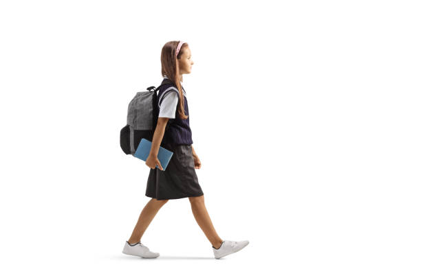 istock Schoolgirl holding books and walking 1336618794