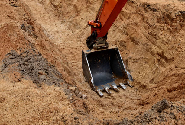 istock Excavator bucket for digging a pit and ditch at construction site. 1336620352