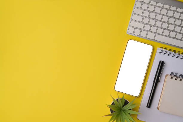 istock Mock up smart phone, notebook and keyboard on yellow background 1336621644