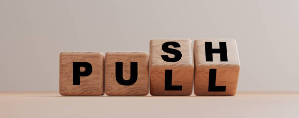 bloque de madera volteando entre push y la redacción de la encuesta en la mesa. - pulling fotografías e imágenes de stock