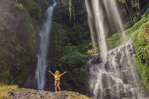 niño en las cascadas de sekumpul en las selvas de la isla de bali, indonesia. concepto de viaje de bali - waterfall river stream mountain fotografías e imágenes de stock