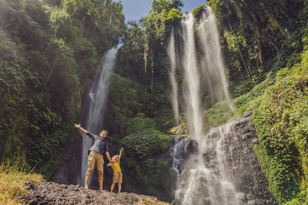 papá e hijo en las cascadas de sekumpul en las selvas de la isla de bali, indonesia. concepto de viaje de bali - stream forest river waterfall fotografías e imágenes de stock