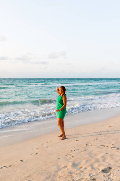 istock Girl walks along the beach in a dress 1336625607