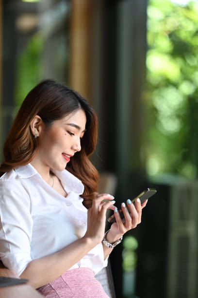 istock Smiling young woman using mobile phone in office. 1336626619