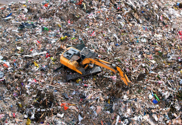 istock Garbage dump with construction waste. Excavator during recycling of waste at junk yard 1336627300