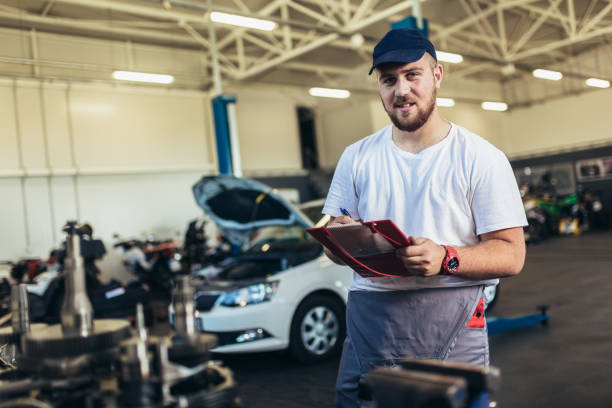 istock Man writing on a clipboard in a garage. 1336627308